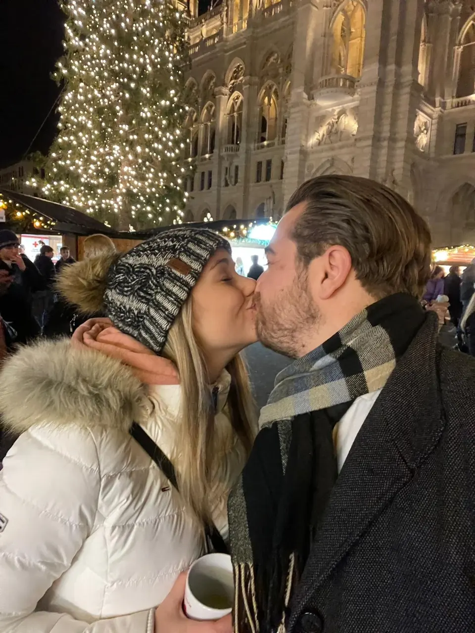Helene und Philipp küssen sich vor weihnachtlicher Beleuchtung